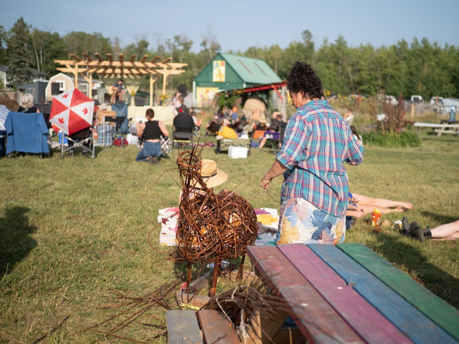 Festival-goers gathered near the stage with the willow goat taking shape